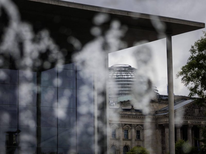 Paul-Loebe-Haus und der Deutsche Bundestag hinter Scheibe mit Regenwasser