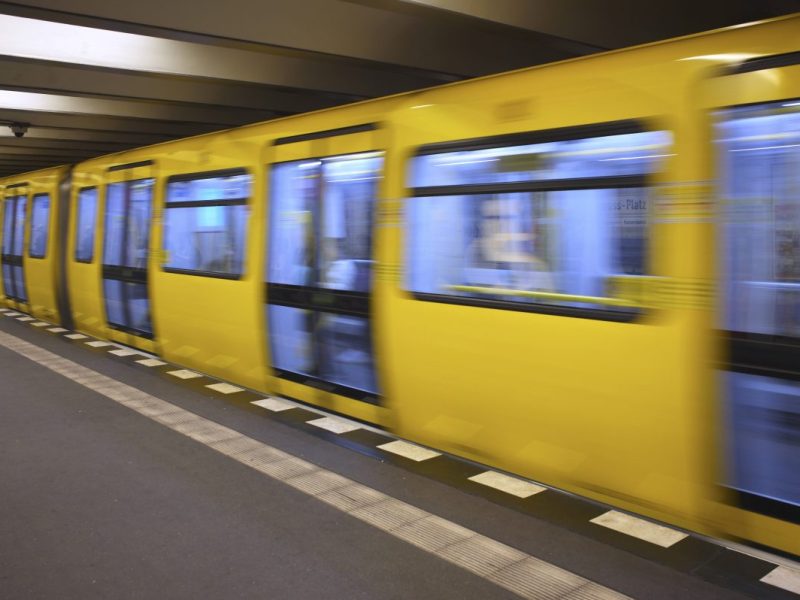 Eine Berliner U-Bahn fährt an einem Bahnhof ein.