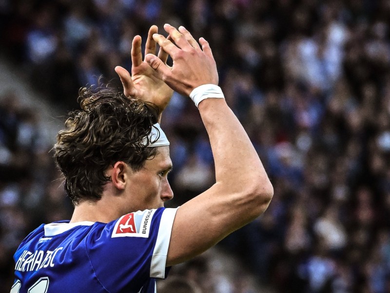 Fabian Reese von Hertha BSC hebt die Arme über den Kopf.