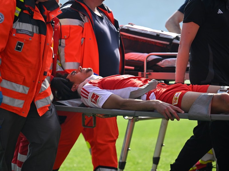 Diogo Leite, Abwehrspieler von Union Berlin, wird von Sanitätern vom Platz getragen.
