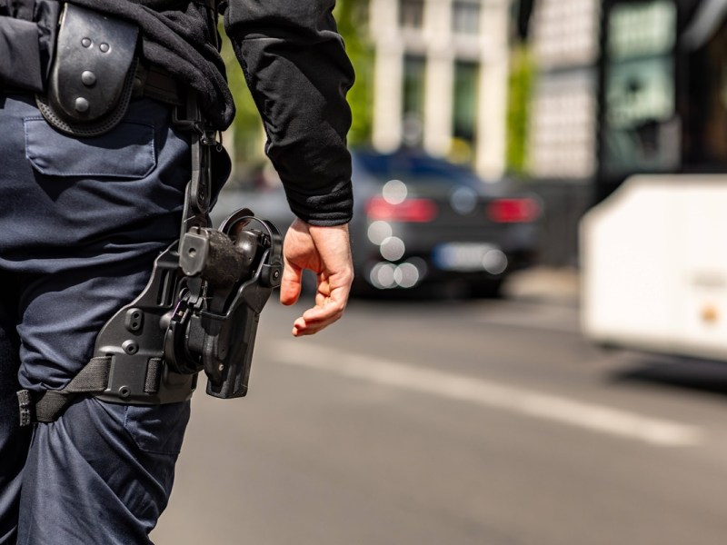 Ein Berliner Polizist steht an einer Straße.