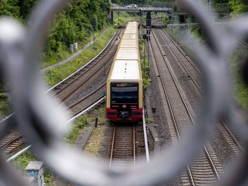 Ein Zug der S-Bahn Berlin durch ein Brückengeländer fotografiert.
