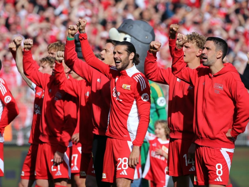 Die Spieler von Union Berlin jubeln mit den Fans.